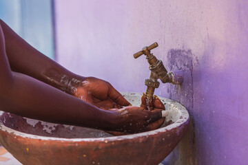 African woman washes her hands outdoors in a small village Keta Ghana West Africa