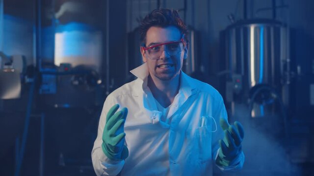 Portrait of crazy scientist laughing at camera in large smoky laboratory