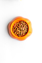 dry dog food in bowl on white background top view