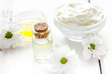 Obraz na płótnie Canvas close up body care camomile cosmetic products on white wooden desk background