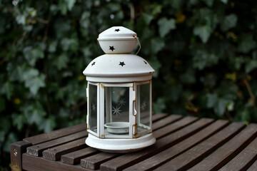 Małe latarenki na drewnianym stoliku , na tle bluszczu. © Krzysztof Głowacki