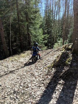 A little boy is enjoying his motocross ride in various poses on nature trails.