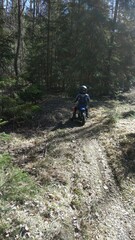 A little boy is enjoying his motocross ride in various poses on nature trails.