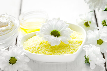 camomile salt in cosmetic set on table background