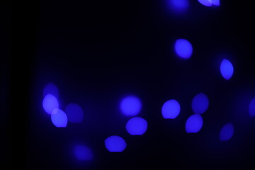 Background of blue bokeh (led strip light in a 50mm lens) on a dark black background.  Design...