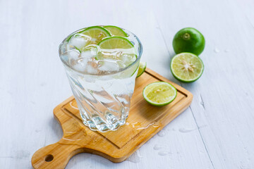 A glass of soda, lemon and lime on the table