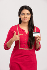 Beautiful young woman holding credit card on white.