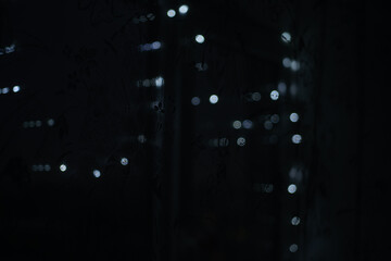 Fototapeta na wymiar Electric garland on the window. bokeh background of Christmas lights, selective focus.