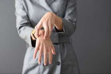Obraz premium Woman in gray dress scratching her hands close-up