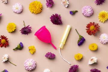Menstrual cup and tampons on floral pattern background