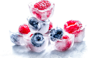 fresh blueberry and raspberry in ice on table background