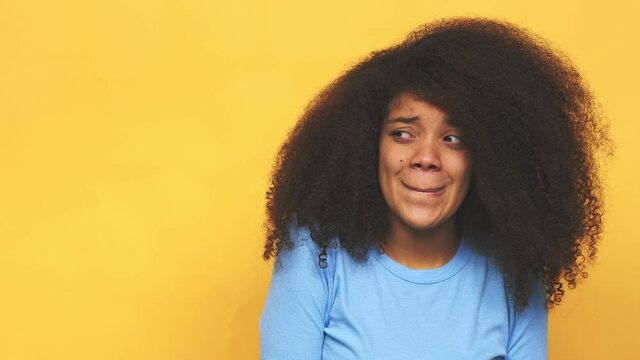 Young african american curly woman confused, feels doubtful and unsure