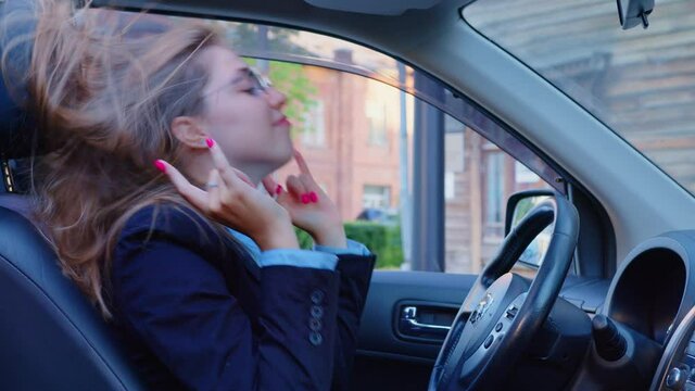 A Young Funny Woman Is Dancing In The Car. An Office Worker Or A Business Woman Is Shaking Head And Hands At The Driver Seat After A Work Day