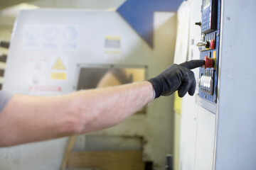 worker activating a machine button