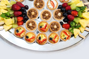 The buffet at the reception. Assortment of canapes on a table. Banquet service. Catering food, snacks with different types of cheese, ham, salami, prosciutto, shrimp, vegetables and fruits. Party Conc