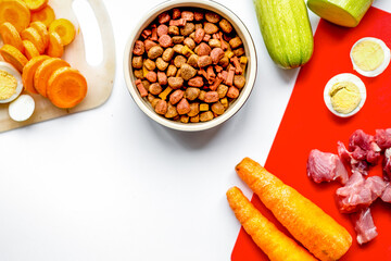 sliced vegetables and petfood on kitchen table background top view mock up
