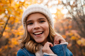 Happy girl walking outdoors in autumn park