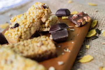 Granola Bars and mixed nuts. Honey bars with peanuts, chocolate, dried fruit, sesame and sunflower seeds