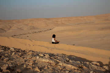 Girl meditating in desert