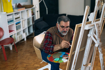senior man painting at his home