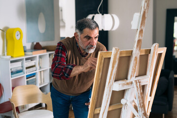 senior man painting at his home