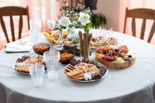 The buffet at the reception. Assortment of canapes on a table. Banquet service. Catering food, snacks with different types of cheese, ham, salami, prosciutto, shrimp, vegetables and fruits. 