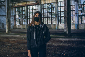 Fototapeta premium Young Girl with Mask in Empty Broken Factory Hall