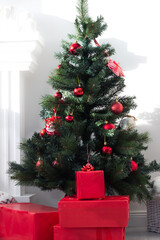 green Christmas tree with Christmas balls and gifts under the tree