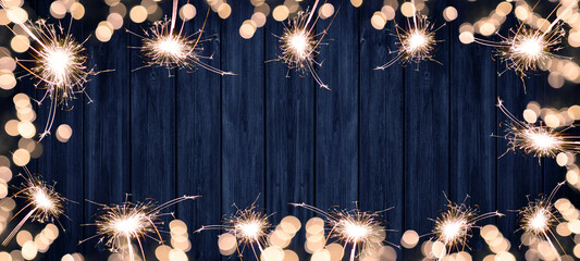 Frame made of lights bokeh flares and sparkler isolated on rustic blue wooden wood table texture -...