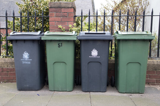Wheely bins on pavement awaiting collection with North Tyneside Council crest and signage