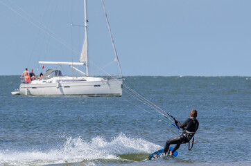 Naklejka premium KITSURFER AND SAILBOAT - Active recreation on the water 