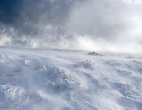 A mountain slope covered with a layer of snow during strong winds. Trapped in motion.
