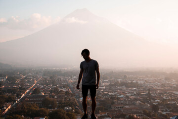 young traveler overlooking antigua guatemala and agua volcano