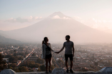 Obraz premium couple holding hands silhouette in front of agua volcano in antigua guatemala