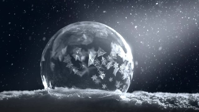Frozen Christmas ball freezing in cold winter snow flake snowing isolated on black background