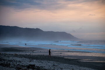 Fototapeta na wymiar silhouette of man walking towards the beach at sunset in costa rica