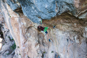 A young athlete climbs a rock