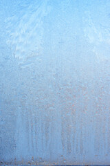 Beautiful natural background or texture of frozen transparent glass on the window in winter, extreme cold concept, vertical image, copy space for your design or text