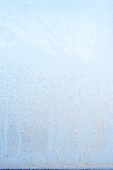 Beautiful natural background or texture of frozen transparent glass on the window in winter, extreme cold concept, vertical image, copy space for your design or text