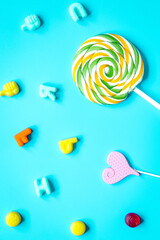Colorful candies scattered on blue background top view pattern