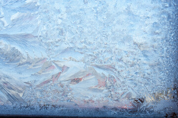 Winter background on a transparent glass of a window with a frozen texture. Abstract texture...