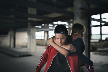 Teenage boy attacked by thug in abandoned building, gang violence and bullying concept.