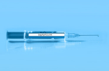 Obraz premium close up of a syringe with the german inscription vaccination obligation