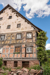 Fototapeta na wymiar Fassade von einem alten verlassenen Fachwerkhaus mit teils begonnener Renovierung