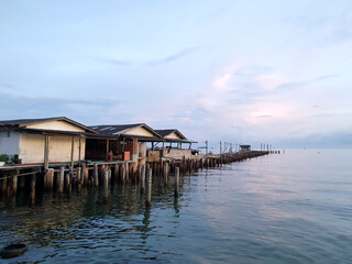 traditional fisherman's house on the wooden bridge that located overwater. twilight scenic of Thailand Rayong sea.
