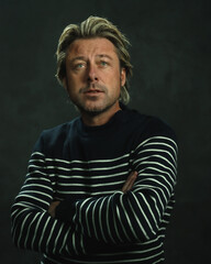 Man with blonde hair in striped fisherman's sweater. Studio portrait.