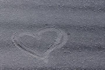 The heart is drawn on ice. Spot focus. Sun light reflected on ice