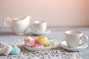 Meringues of a delicate pastel color are on the table for morning tea