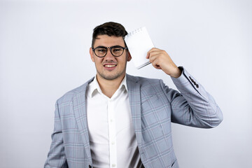 Business young man wearing a casual shirt over white background holding a blank notebook