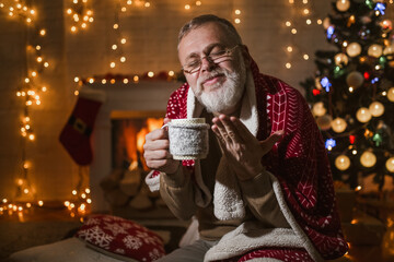 Man sitting and relaxation near fireplace and christmas tree.